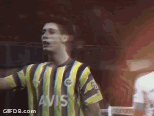A Man Wearing A Yellow And Black Striped Shirt That Says Avis On It GIF