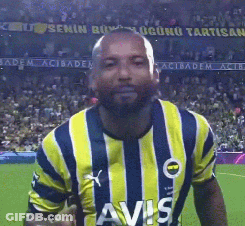 A Man Wearing A Yellow And Blue Striped Shirt With Avis On The Front GIF