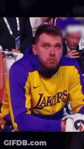 A Man Wearing A Yellow And Purple Lakers Jacket GIF