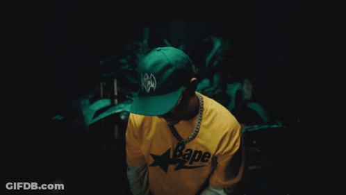 A Man Wearing A Yellow Bape Shirt And Sunglasses GIF