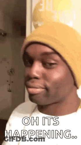 A Man Wearing A Yellow Beanie Is Making A Funny Face And Saying `` Oh It 'S Happening . '' GIF