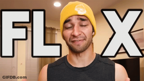 A Man Wearing A Yellow Beanie With A Skull On It Stands In Front Of A Sign That Says Flix GIF