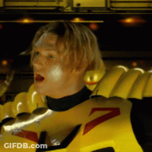 A Man Wearing A Yellow Costume With A Red Arrow On It GIF