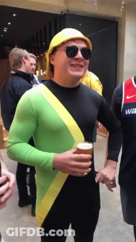 A Man Wearing A Yellow Hard Hat And Sunglasses Is Holding A Glass Of Beer GIF