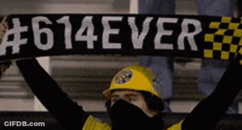A Man Wearing A Yellow Hard Hat Holds Up A Scarf That Says # 614Ever GIF