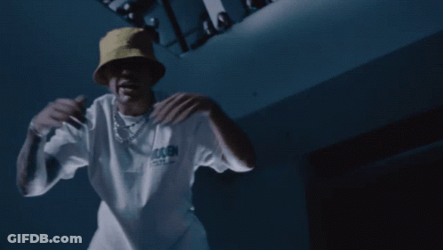 A Man Wearing A Yellow Hat And A White T-Shirt That Says Trash GIF