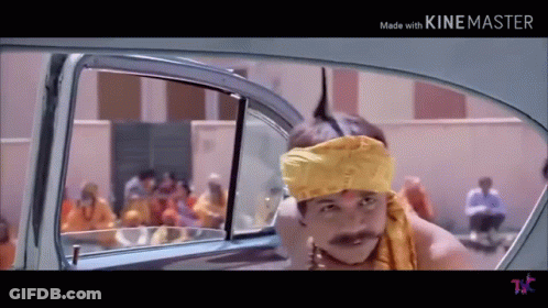 A Man Wearing A Yellow Headband And A Mustache Is Sitting In The Back Of A Car . GIF