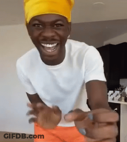 A Man Wearing A Yellow Headband Is Smiling And Pointing At The Camera GIF