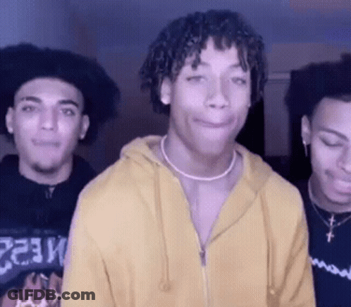 A Man Wearing A Yellow Hoodie Is Standing With Two Other Men GIF