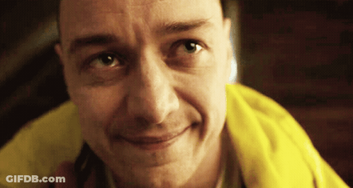 A Man Wearing A Yellow Jacket Is Smiling And Looking At The Camera GIF