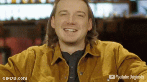 A Man Wearing A Yellow Jacket Is Smiling In Front Of A Youtube Originals Logo GIF
