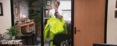 A Man Wearing A Yellow Jacket Is Standing In An Office GIF