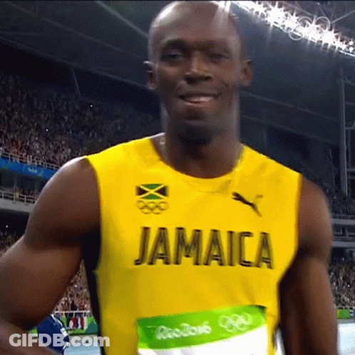 A Man Wearing A Yellow Jamaica Jersey Is Smiling GIF