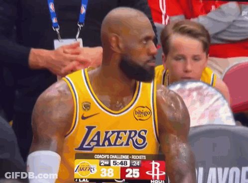 A Man Wearing A Yellow Lakers Jersey Looks At The Camera GIF