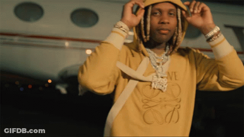 A Man Wearing A Yellow Loewe Sweatshirt Is Adjusting His Hood GIF