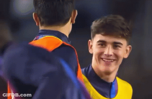 A Man Wearing A Yellow Nike Vest Is Smiling While Talking To Another Man GIF