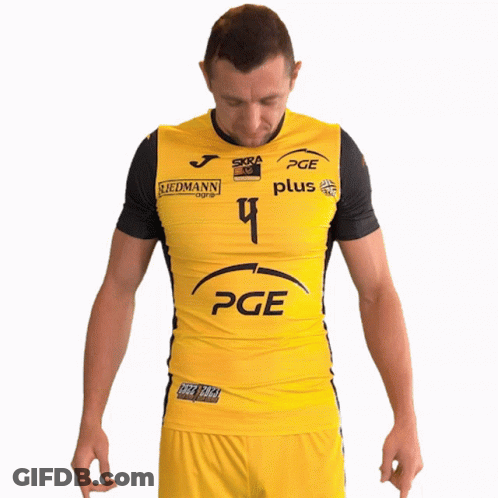 A Man Wearing A Yellow Pge Shirt Stands With His Hands On His Hips GIF