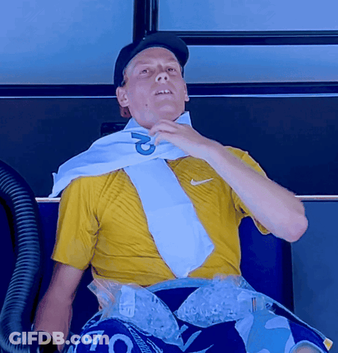 A Man Wearing A Yellow Shirt And A White Scarf With The Letter P On It GIF