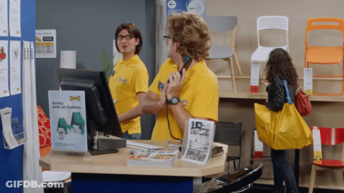 A Man Wearing A Yellow Shirt That Says Ikea On It Is Talking On A Phone GIF