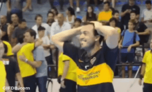 A Man Wearing A Yellow Shirt That Says Uruguay On It Is Holding His Head . GIF
