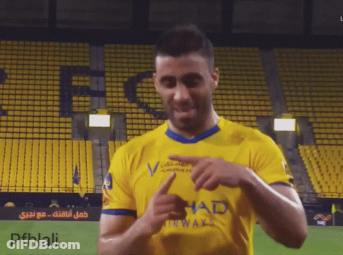 A Man Wearing A Yellow Shirt With Had On It GIF