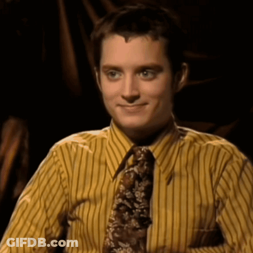 A Man Wearing A Yellow Striped Shirt And Tie Smiles For The Camera GIF