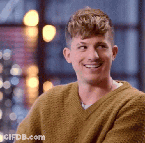 A Man Wearing A Yellow Sweater Is Smiling And Looking Up GIF