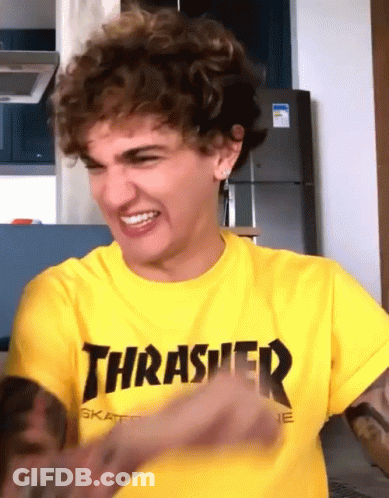 A Man Wearing A Yellow Thrasher Shirt Is Making A Face GIF