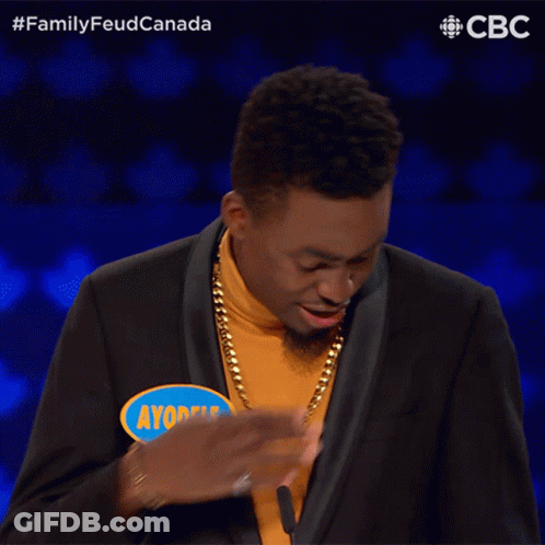 A Man Wearing A Yellow Turtleneck And A Black Suit Has Ayobele Written On A Blue Sticker GIF