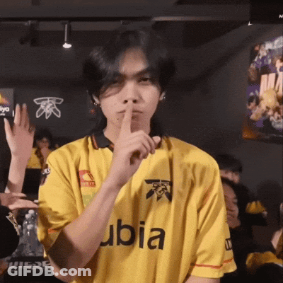 A Man Wearing A Yellow Ubia Shirt Holds His Finger To His Lips GIF