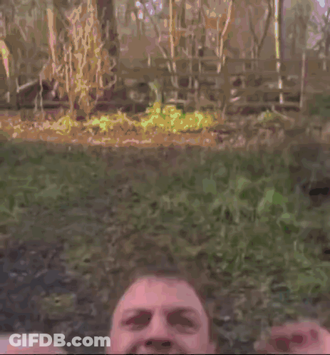 A Man Wearing A Yellow Vest And Tie Is Screaming With His Mouth Wide Open . GIF