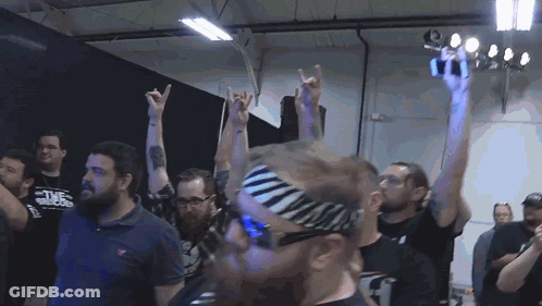 A Man Wearing A Zebra Print Headband Holds Up His Hands GIF