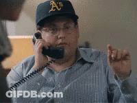 A Man Wearing An A's Hat Is Talking On A Telephone GIF