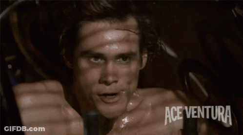 A Man Wearing An Ace Ventura Watch Waves His Hand GIF