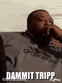 A Man Wearing An Adidas Shirt Is Smoking A Cigarette And Says Dammit Tripp . GIF