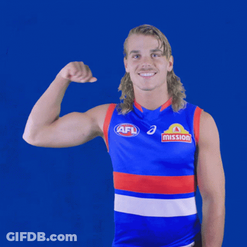 A Man Wearing An Afl Jersey Is Flexing His Muscles GIF
