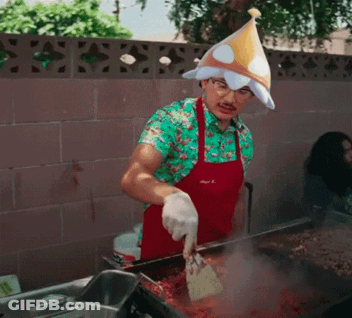 A Man Wearing An Apron And A Party Hat Is Cooking GIF