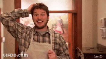 A Man Wearing An Apron And A Plaid Shirt Is Scratching His Head In A Kitchen . GIF