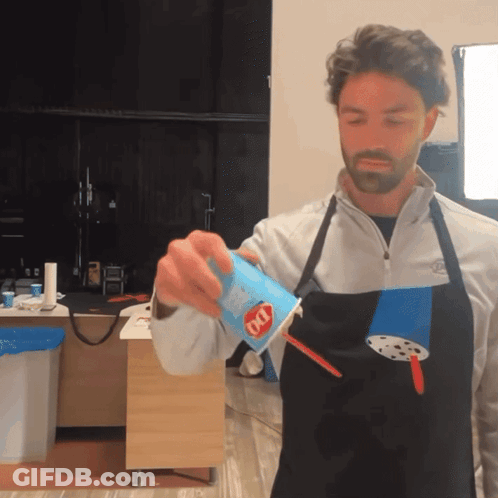 A Man Wearing An Apron Is Pouring A Drink Into A Cup That Says Dq On It GIF