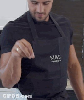 A Man Wearing An Apron That Says M & S Food On It GIF