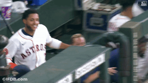 A Man Wearing An Astros Jersey Is Standing In The Dugout GIF
