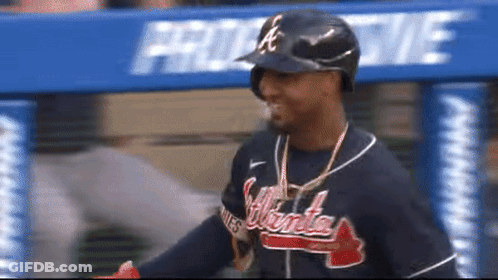 A Man Wearing An Atlanta Braves Jersey And A Helmet GIF