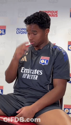 A Man Wearing An Emirates Fly Better Jersey Sits On A Red Chair GIF