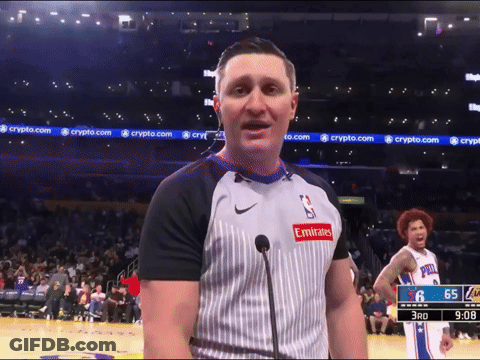 A Man Wearing An Emirates Shirt Stands In Front Of A Microphone On A Basketball Court GIF