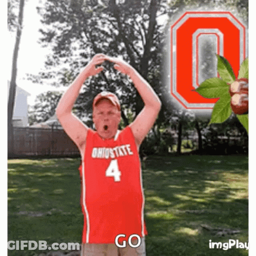 A Man Wearing An Ohio State Jersey With The Number 4 On It Stands In Front Of An Ohio State Logo GIF