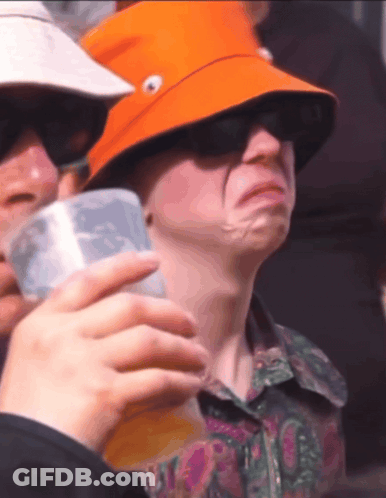 A Man Wearing An Orange Hat Is Holding A Cup Of Beer GIF