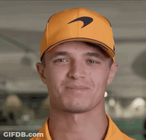 A Man Wearing An Orange Hat With A Mclaren Logo GIF