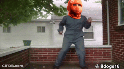 A Man Wearing An Orange Hat With Ny On It GIF