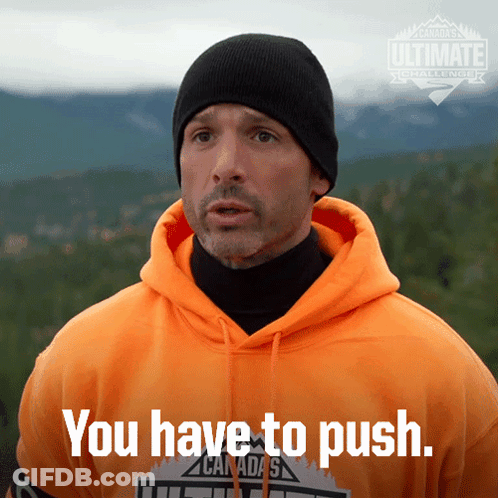 A Man Wearing An Orange Hoodie And A Black Beanie Says " You Have To Push " GIF