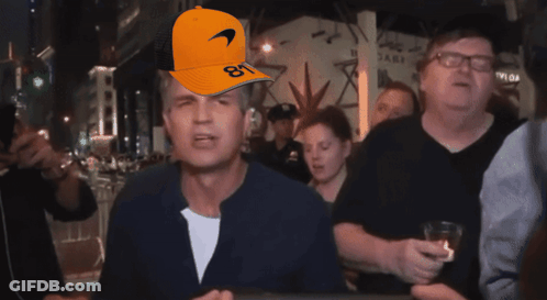 A Man Wearing An Orange Mclaren Hat With The Number 81 On It GIF
